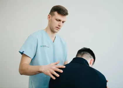Fisioterapeuta valorando la postura de un paciente de pie
